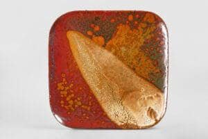 Assiette carrée en céramique avec émail coloré et texture unique.