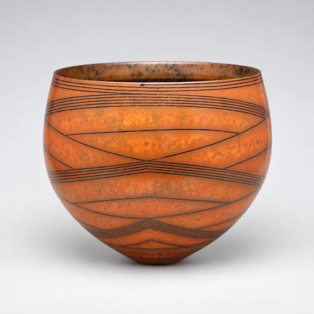 Vase en céramique avec motifs géométriques noirs.
