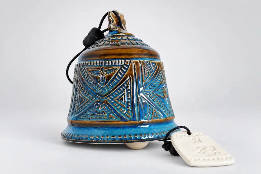 Cloche en céramique bleue avec motifs géométriques.