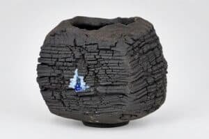 Vase en céramique noire avec texture stratifiée unique.