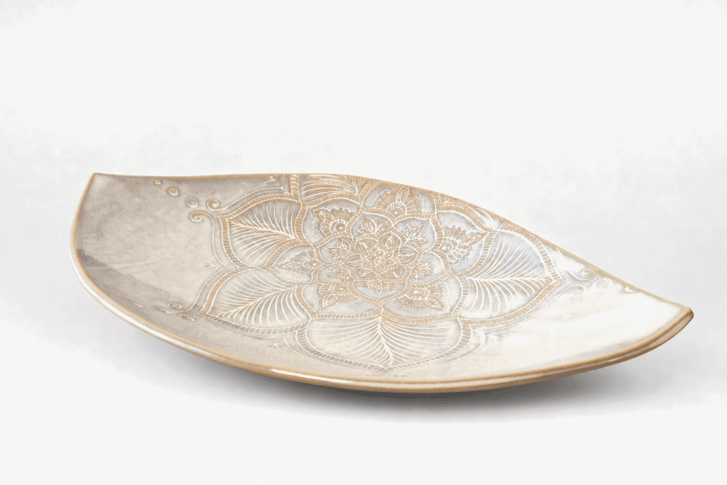 Assiette en céramique avec motif floral gravé.