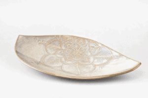 Assiette en céramique avec motif floral gravé.