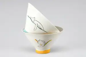 Bol en céramique blanc avec dessin de chat noir et jaune.