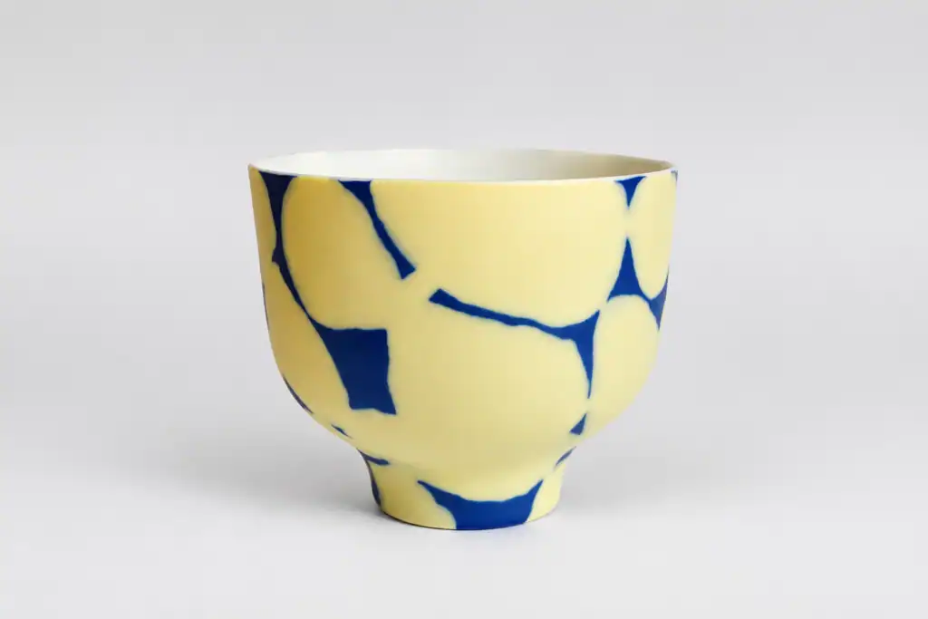 Bol artisanal en céramique avec motif bleu et jaune.