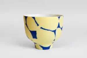 Bol artisanal en céramique avec motif bleu et jaune.