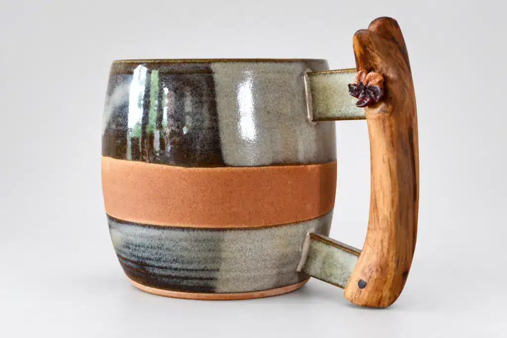 Tasse artisanale en céramique avec manche en bois naturel.