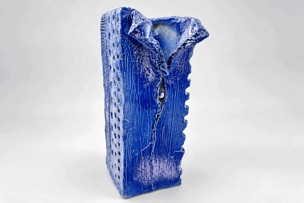 Vase en céramique artisanale émaillée bleue avec texture unique.