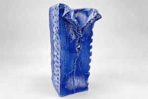 Vase en céramique artisanale émaillée bleue avec texture unique.
